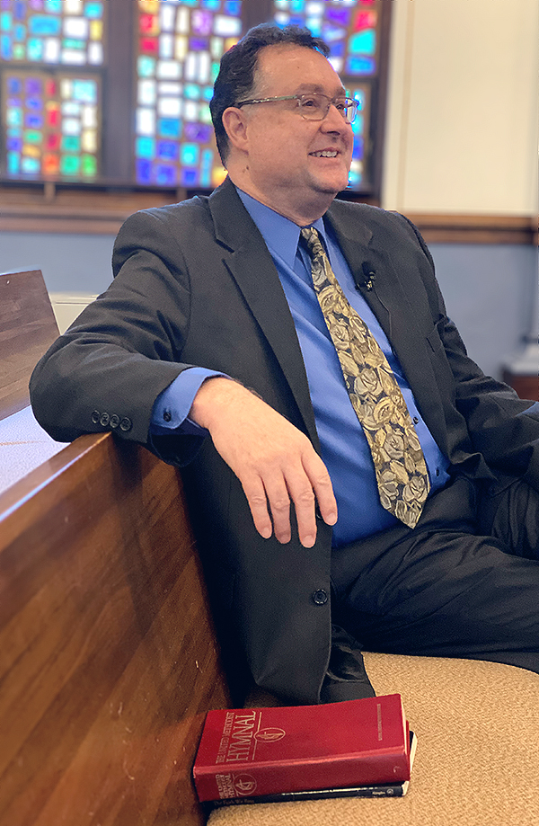 photo of pastor Kent Lolling sitting in pew